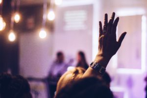 woman raising her hand to ask a question